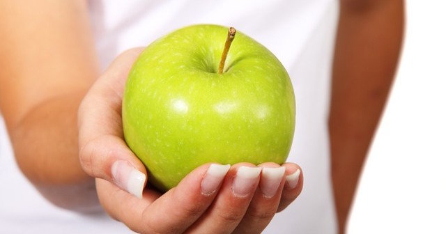 female hand with healthy green apple